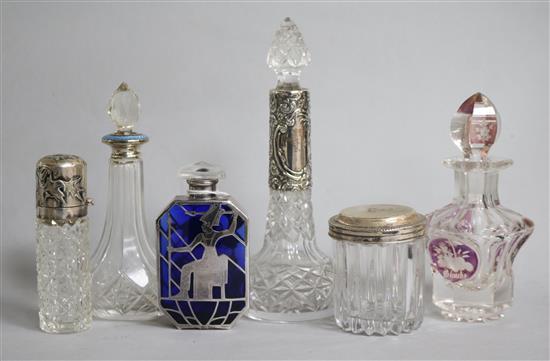 Four assorted mounted scent bottles, a ruby flash glass scent bottle and a silver topped toilet jar.
